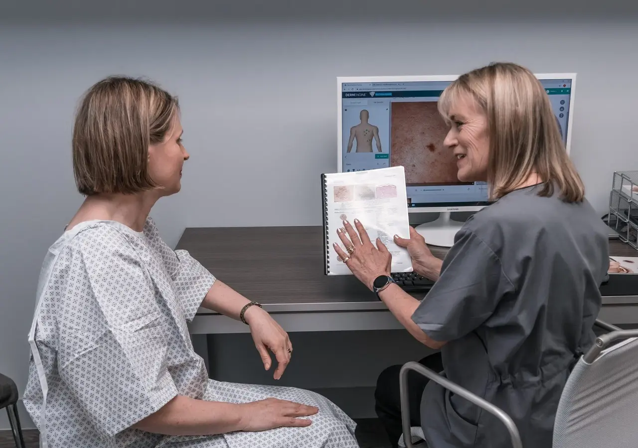 A dermoscopist explaining skin cancers to a patient