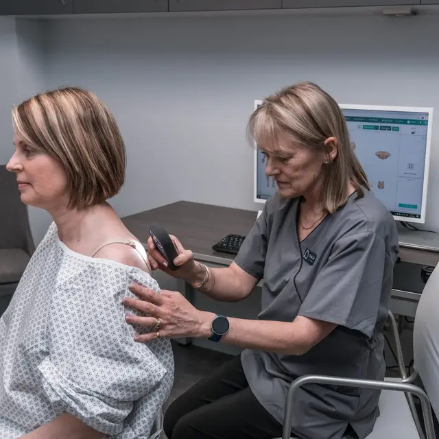 A dermoscopist performing a skin check on a patient